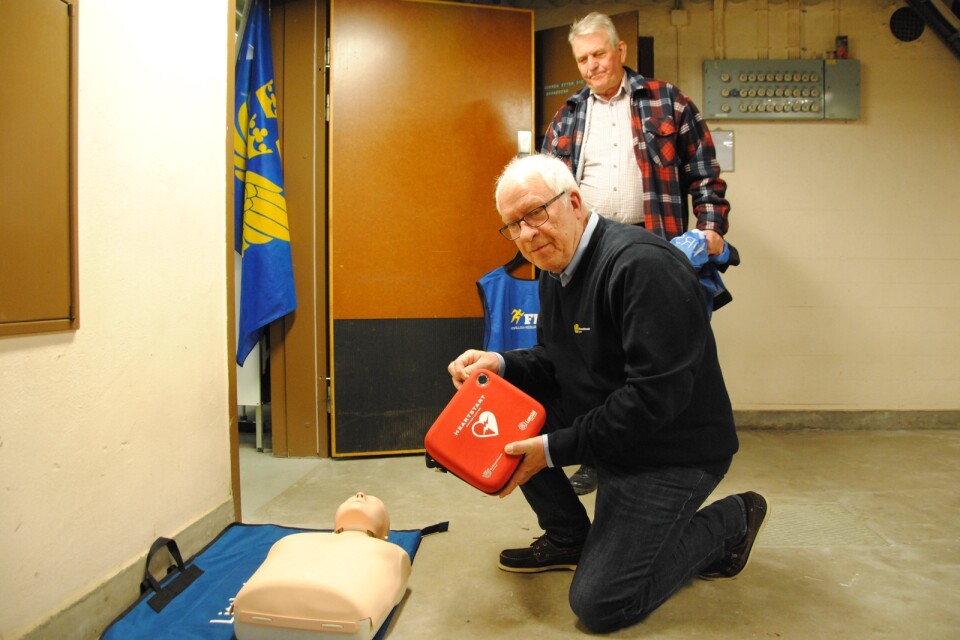 Bo Persson testar hjärtstartaren under överinseende av Lennart Norgren.