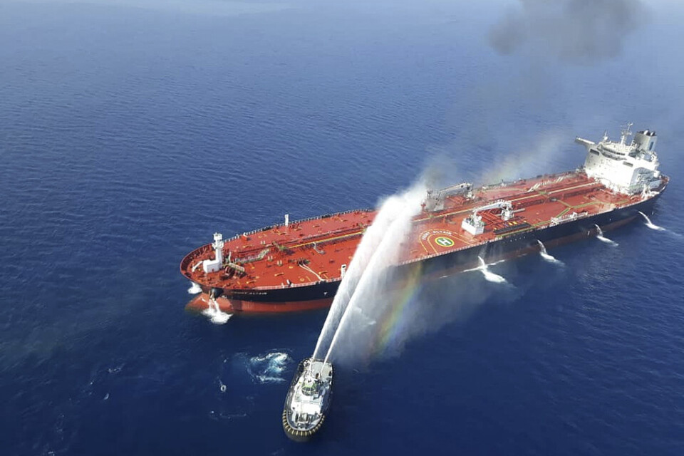 En båt från den iranska flottan i släckningsarbete vid ett av de attackerade fartygen. Bilden publicerades av den iranska nyhetsbyrån Tasnim.