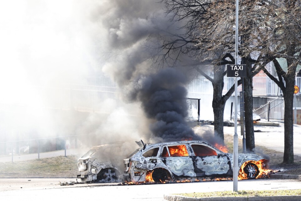 Två bilar brinner på en parkering vid Ringdansen centrum, i samband med upplopp i Navestad i Norrköping.