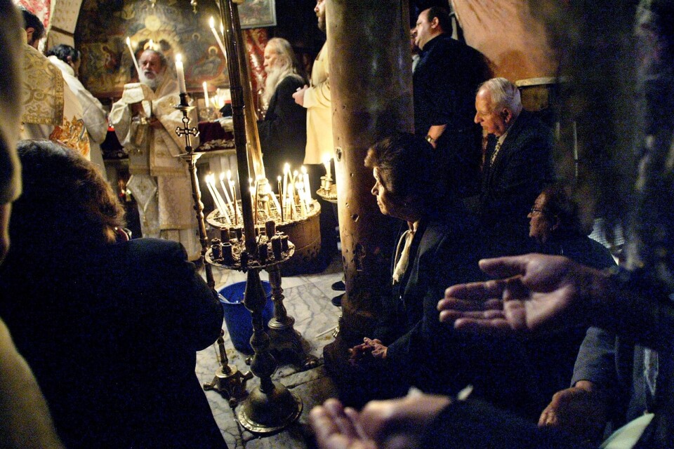 Kristna palestinier ber i Betlehem, där Jesus enligt traditionen föddes. Skribenten efterlyser solidaritet från Svenska kyrkan med det palestinska folket.