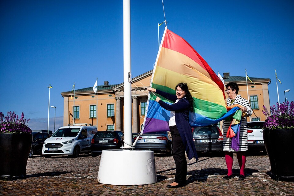 Sophia Ahlin, ordförande i föreningen Karlskrona Pride, och Eva Dahlberg, folkhälsostrateg på Karlskrona kommun, hissar Prideflaggan på Stortorget.
