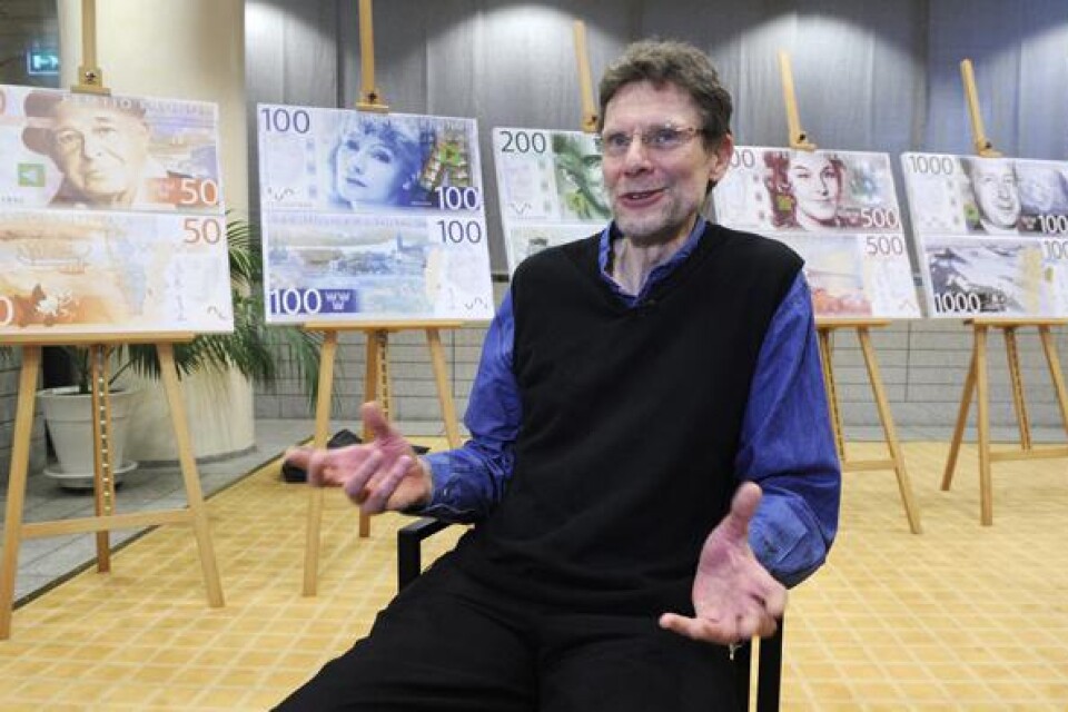 Göran Österlund, grafisk formgivare, framför sedlarna.