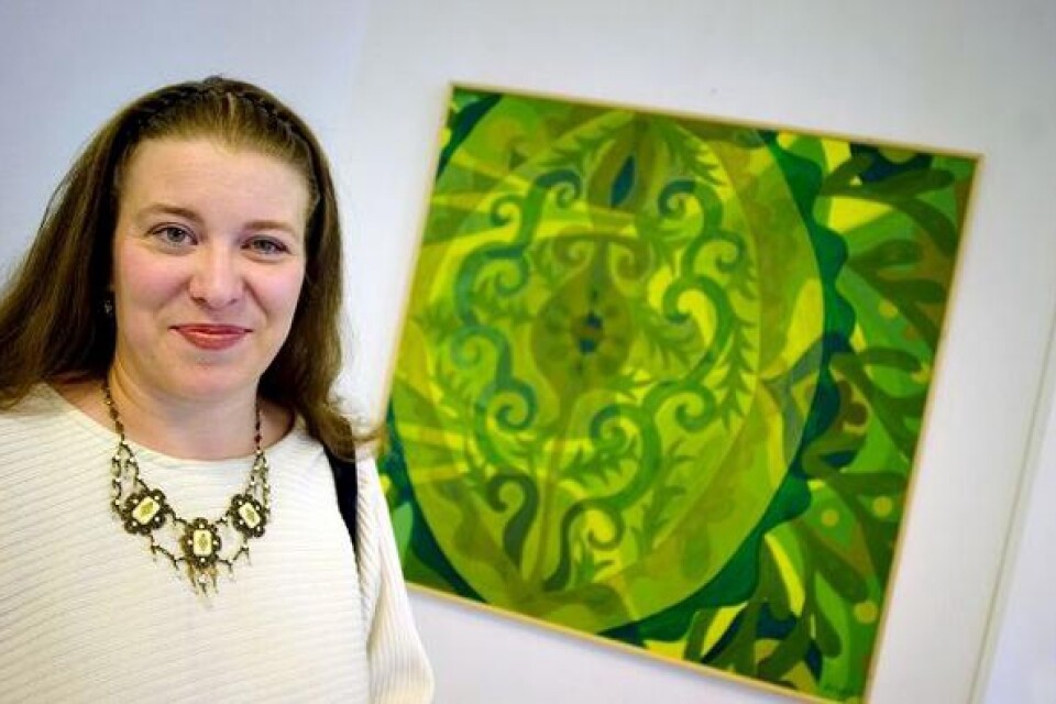 Gabriella Gaál-Lindroos framför den målning i grönt som hon visar på utställningen.