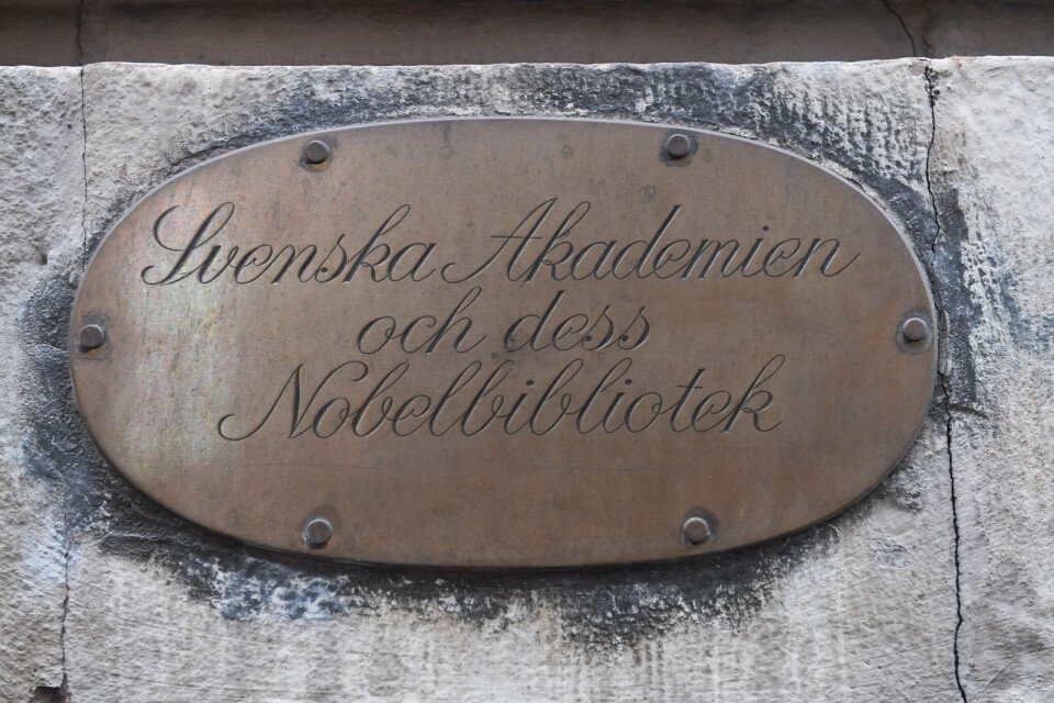 Skylt med texten "Svenska Akademien och dess Nobelbibliotek" utanför Börshuset på Stortorget, Stockholm.