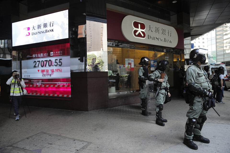 Kravallpolis framför en bank i Hongkong på måndagen.