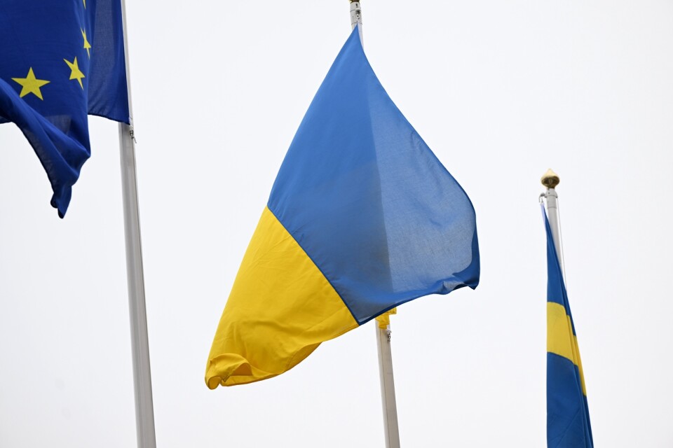 Ukrainas flagga vajar i vinden mellan EU-flaggan och svenska flaggan.