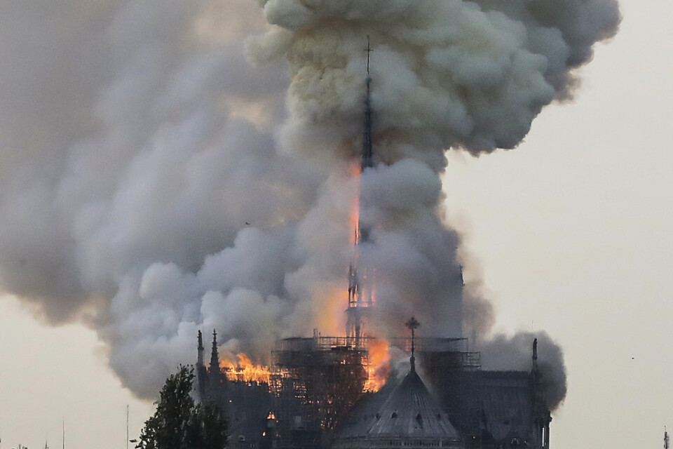 Rök och lågor stiger från medeltidskatedralen Notre-Dame i Paris.