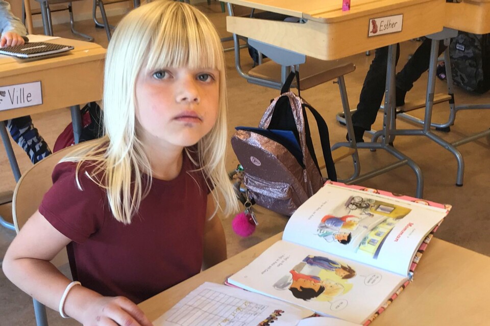 Elna Karlsson tränar på läsläxan och att skriva bokstaven a.