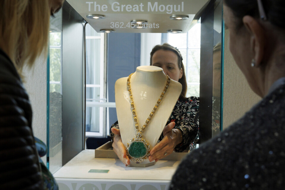 En anställd vid Christie's visar upp en smaragd med tillhörande diamanthalsband inför den kontroversiella auktionen i Genève.