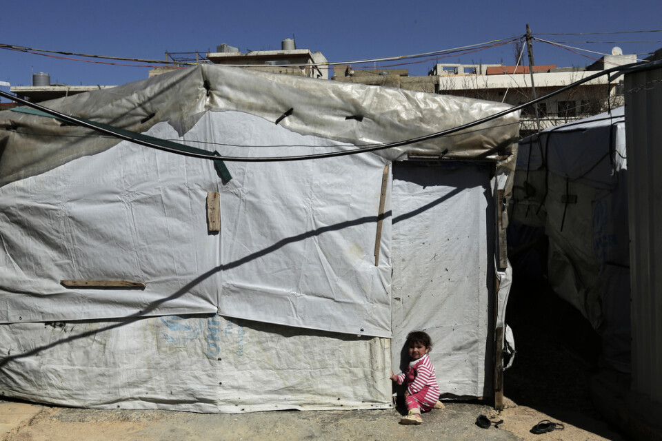 Ett barn utanför ett tält i ett läger för syriska flyktingar i staden Tripoli i norra Libanon. Arkivbild.