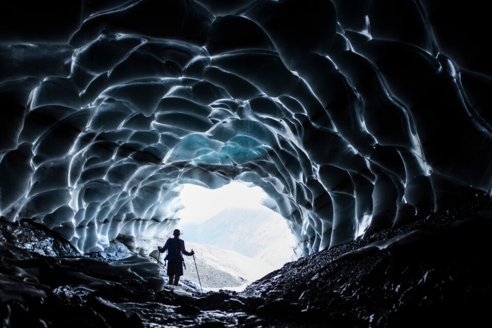 En besökare i en isgrotta i Sardona-glaciären nära Vättis i Schweiz. Sådana turistattraktioner blir nu färre och färre.