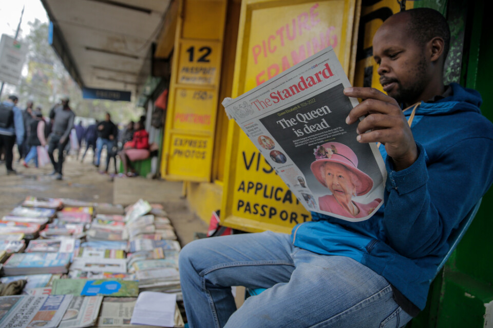 En tidningsförsäljare läser nyheten om drottning Elizabeths död i Kenyas huvudstad Nairobi.