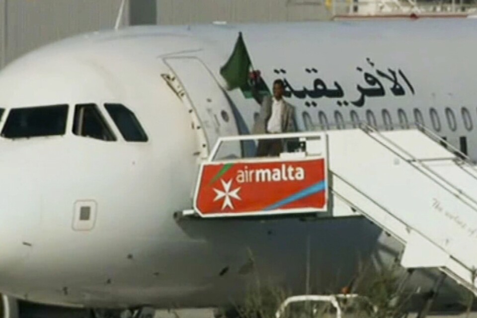 En av kaparna viftar med en flagga utanför flygplanet på Malta i december 2016. Arkivbild.