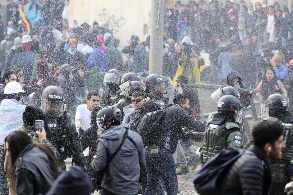 Polisen skingrar demonstranter i centrala Bogotá.