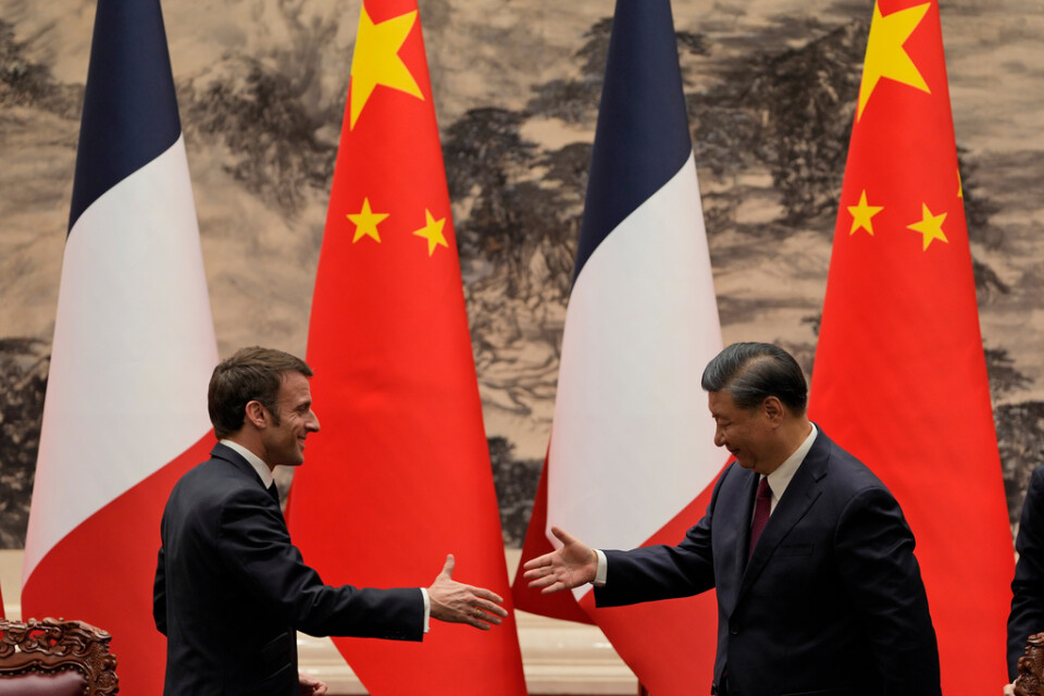 Emmanuel Macron och Xi Jinping skakar hand efter torsdagens möte i Peking.