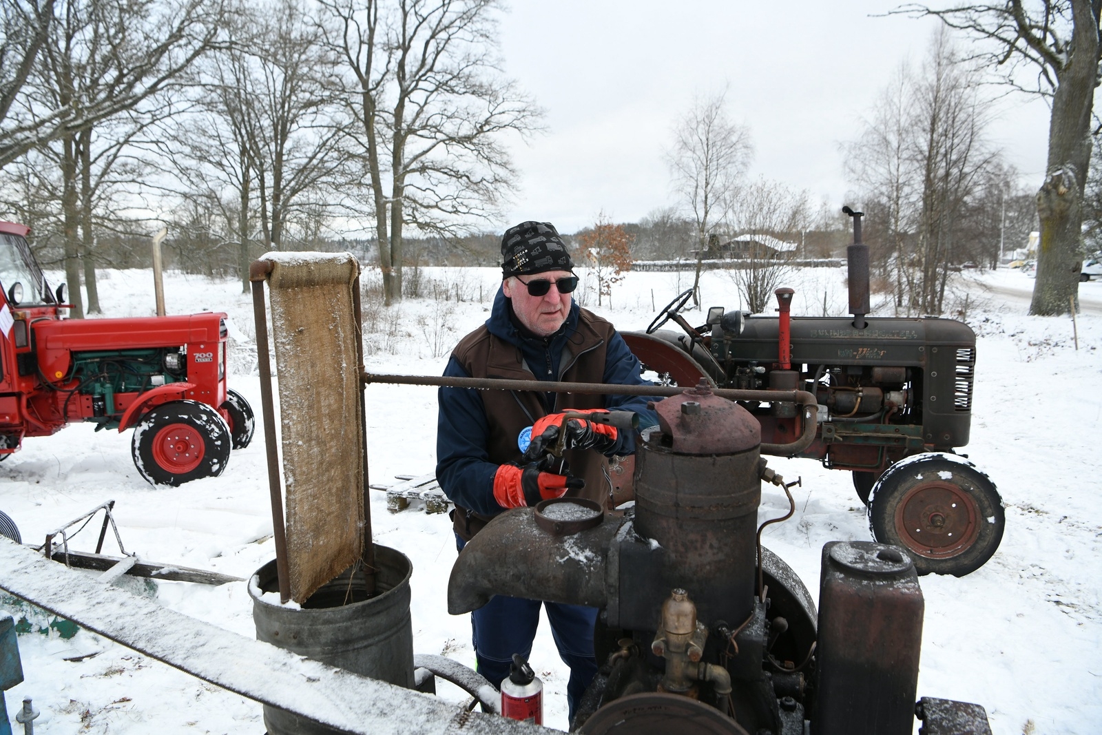 Krister Lennartsson värmer en av motorerna med en gasollåga. Den är lite motvillig men till sist startar den gamla tändkulemotorn.