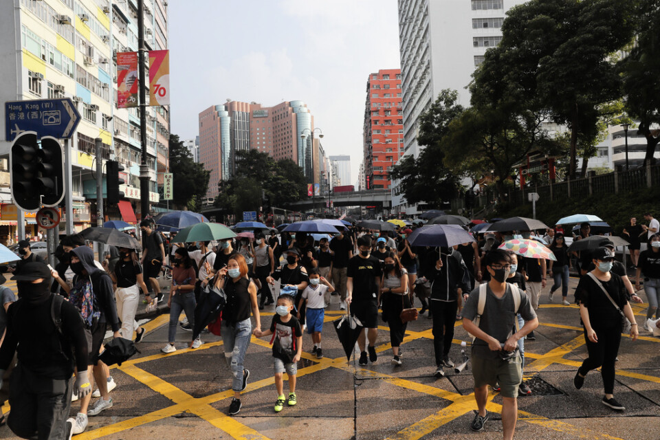 Demonstranter med ansiktsmasker demonstrerar i Hongkong under lördagen.