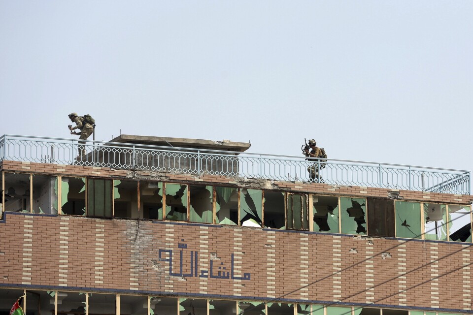 Afghanska säkerhetsstyrkor ovanpå ett tak i anslutning till det attackerade fängelset i staden Jalalabad.