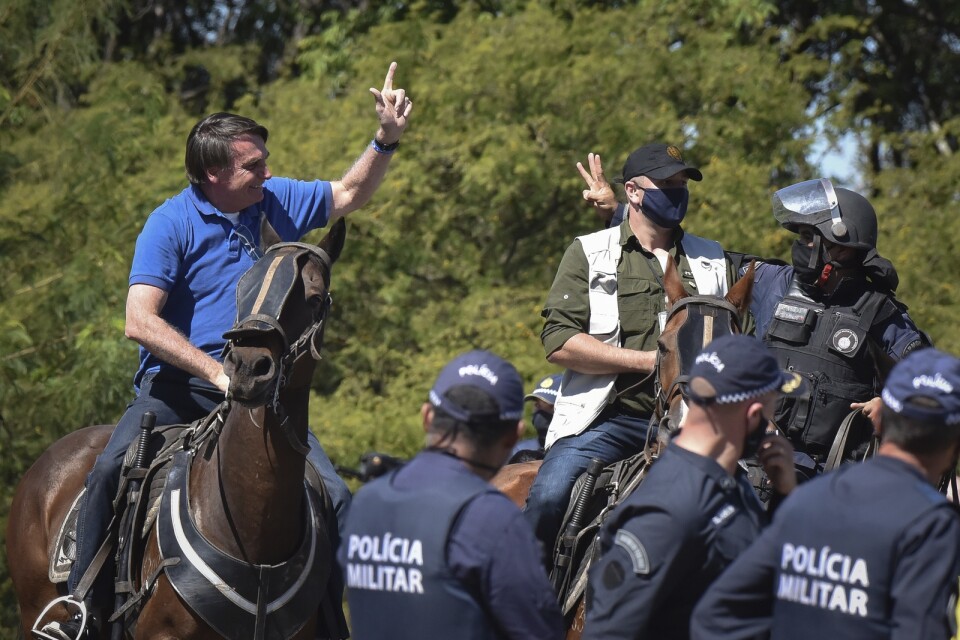 Brasiliens president Jair Bolsonaro ridande på en polishäst vid en protest utanför presidentpalatset i huvudstaden Brasília på söndagen.
