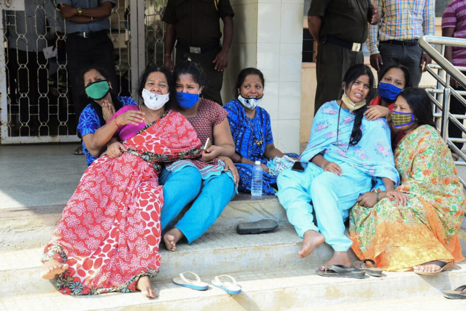 Anhöriga till covidpatienter vakar utanför ett statligt sjukhus i Chamarajanagar i delstaten Karnataka.
