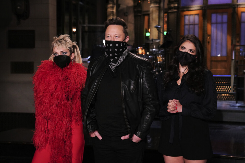 Elon Musk poserar med artisten Miley Cyrus (vänster) och komikern Cecily Strong (höger) inför helgens "Saturday Night Live".