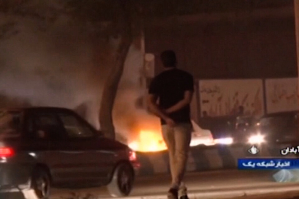 En stillbild från den statliga tv-kanalen Irib visar en mindre eld som anlagts av demonstranter i staden Abadan på lördagen.