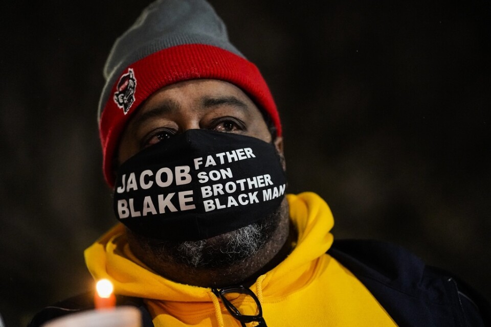 Jacob Blake Sr, far till den skjutne Jacob Blake, håller upp ett ljus vid en vaka för fred och rättvisa i staden Kenosha i Wisconsin på tisdagen.