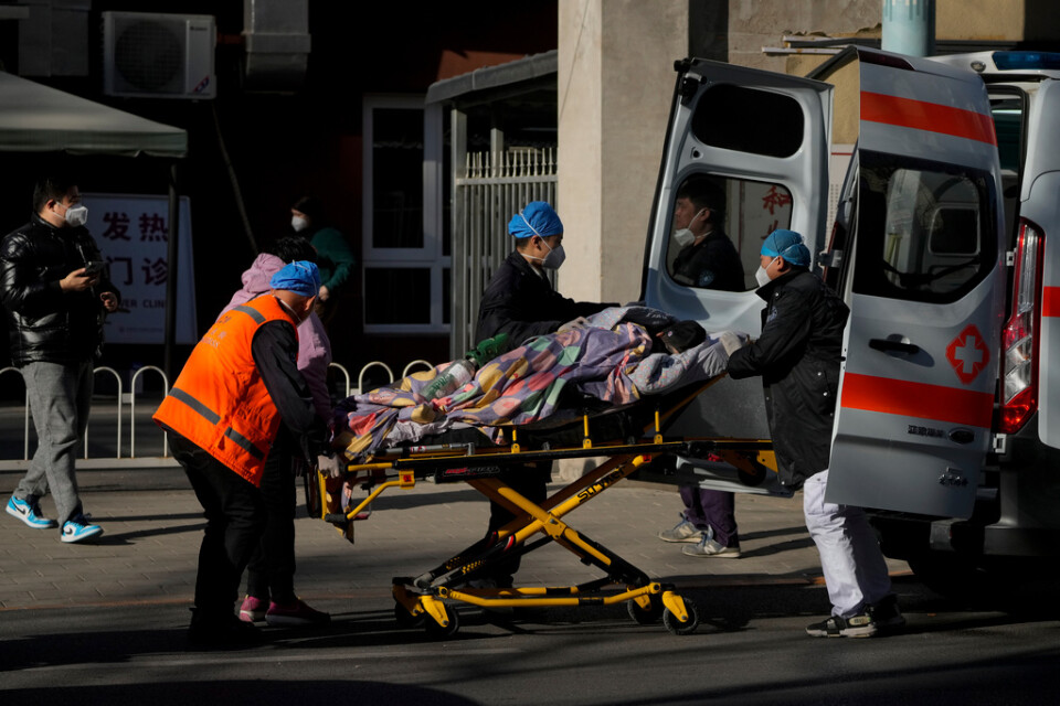 En patient anländer till en så kallad feberklinik i Peking med ambulans. "Feberkliniker" har upprättats över hela landet för att ta hand om covidpatienter.
