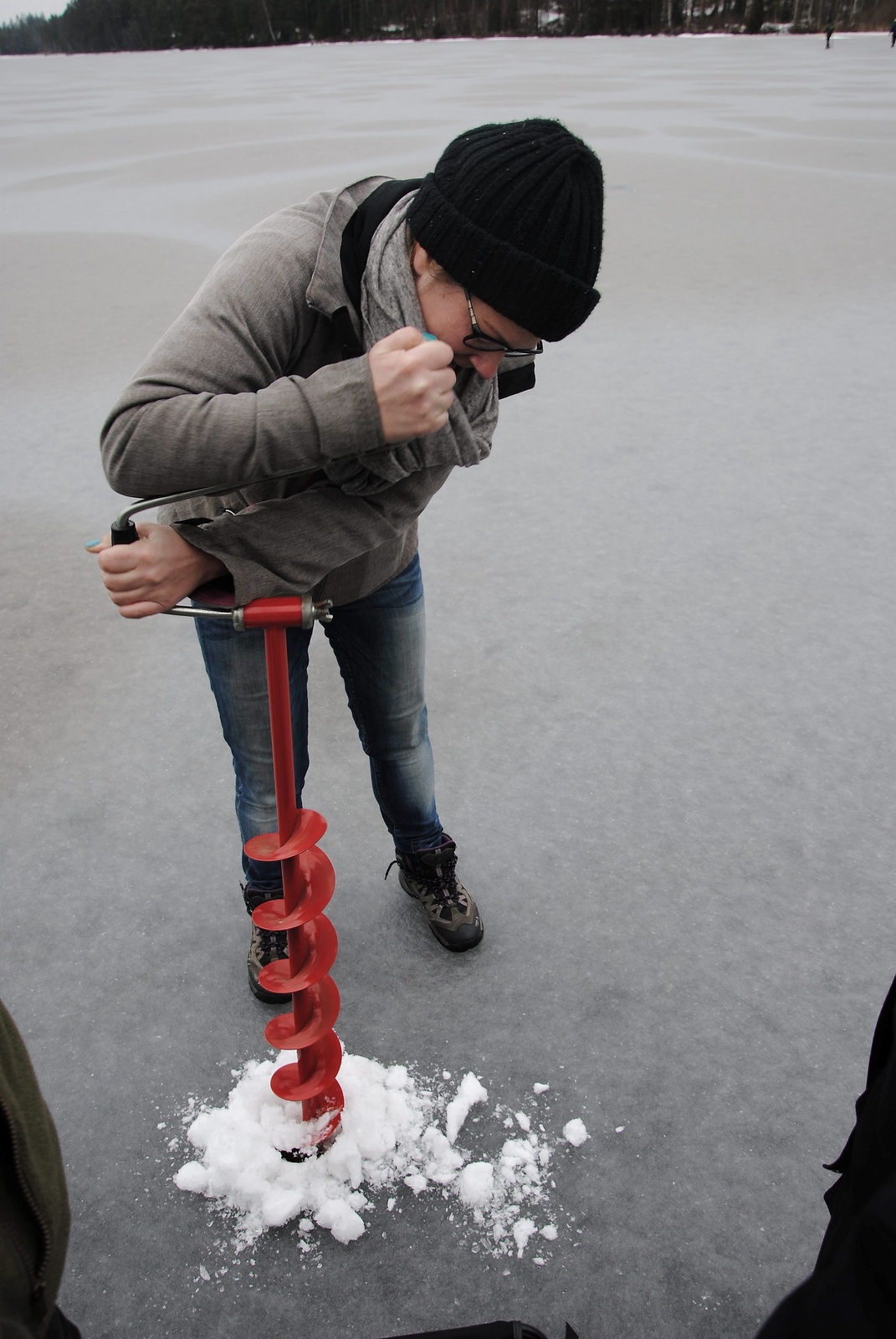 Johanna Johnsson borrar hål i isen.