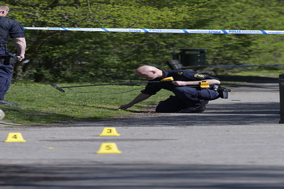 Polisens kriminaltekniker undersöker ett avspärrat område i Malmö på långfredagen efter det att polis skjutit en knivbeväpnad man i benet.