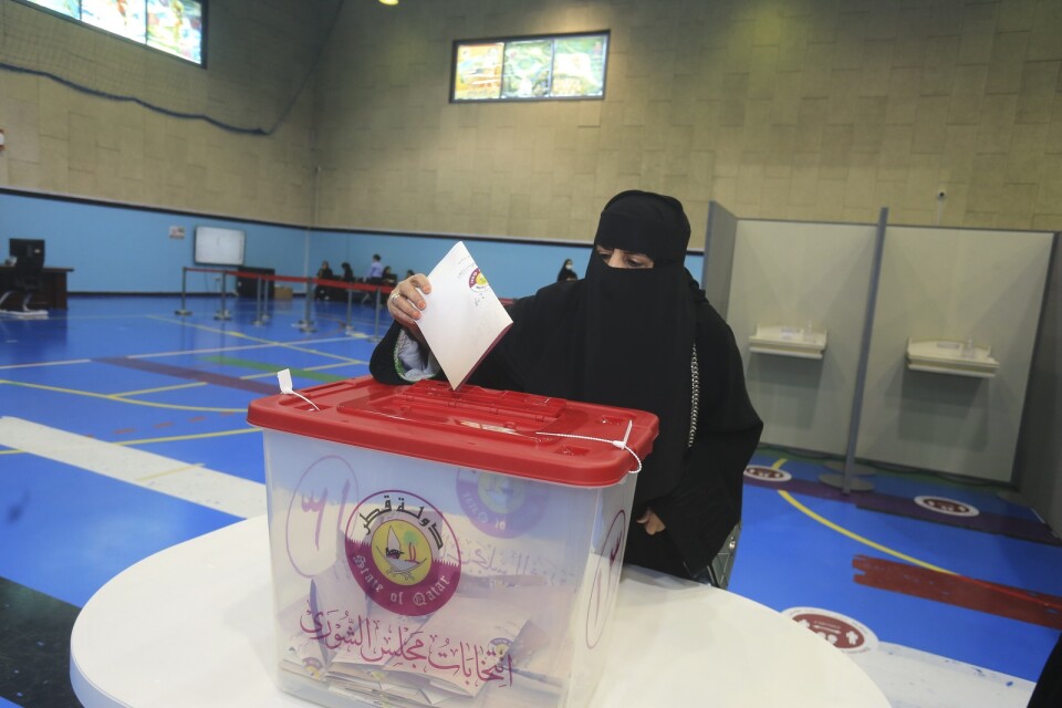 En kvinna lägger sin röst i en vallokal i Doha.