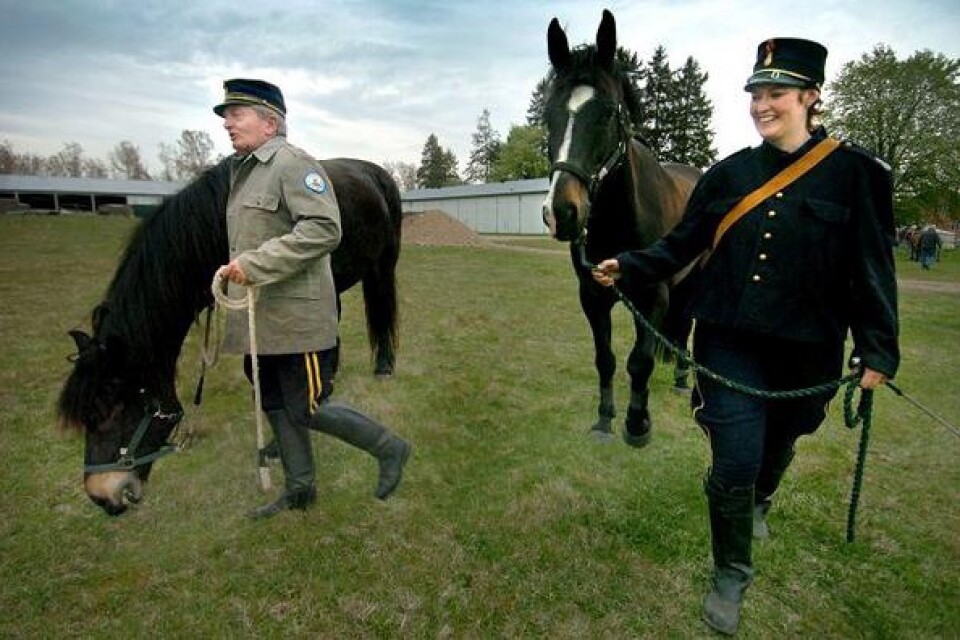 Agne Damgaard och Linda Jönsson i tidstypiska uniformer leder hästarna mot transportvagnarna efter att ha kört ännu en uppvisning.BILD: PETER ÅKLUNDH