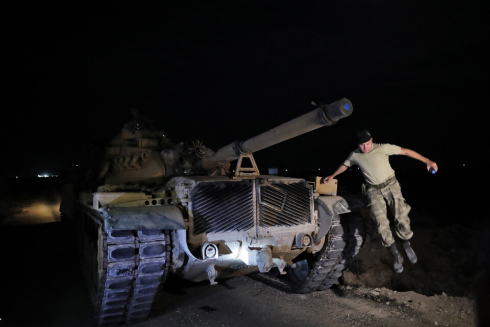 En turkisk arméofficer hoppar ner från en stridsvagn vid gränsen mellan Turkiet och Syrien.