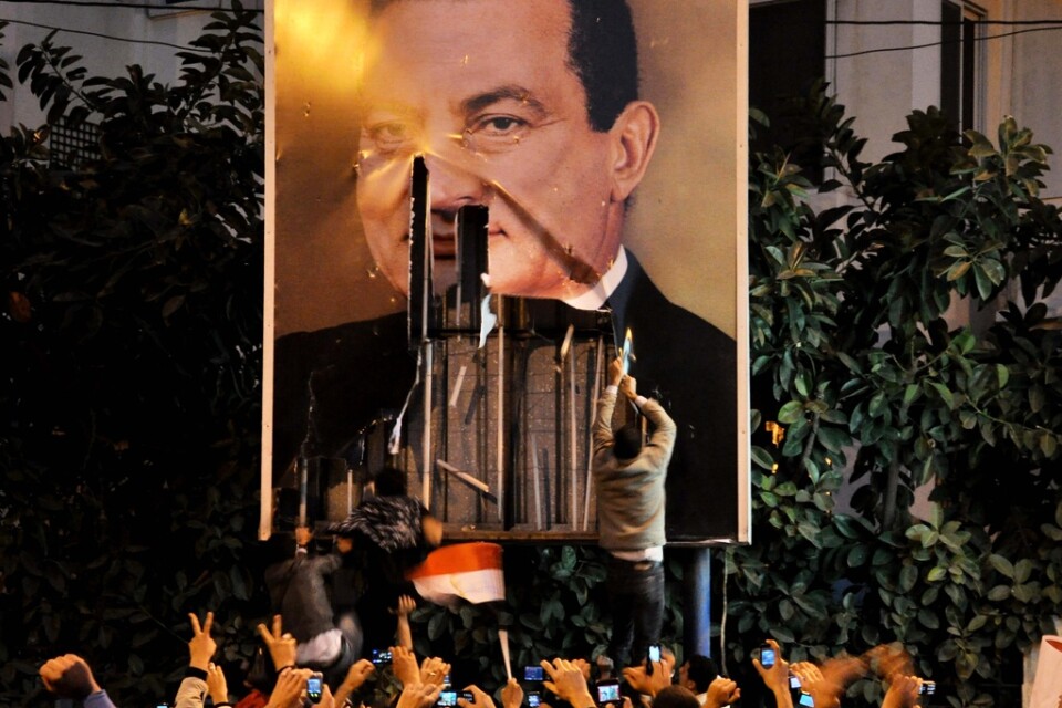 Demonstranter river ned en stor affisch som föreställer Hosni Mubarak i Alexandria, i januari 2011. Arkivbild.