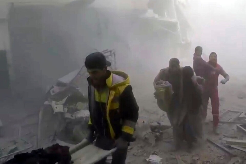 Medlemmar ur frivilligkåren Vita hjälmarna hjälper skadade efter fler luftanfall mot östra Ghouta på lördagen.