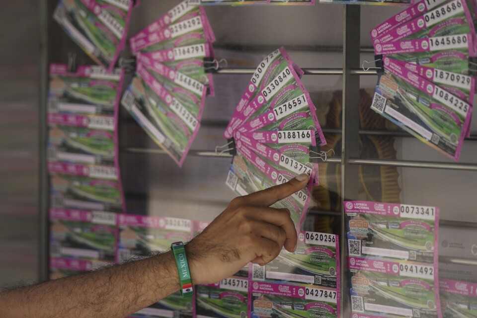 En man pekar på vilken lott han vill köpa i lotteriet där beslagtagna fastigheter kunde vinnas.