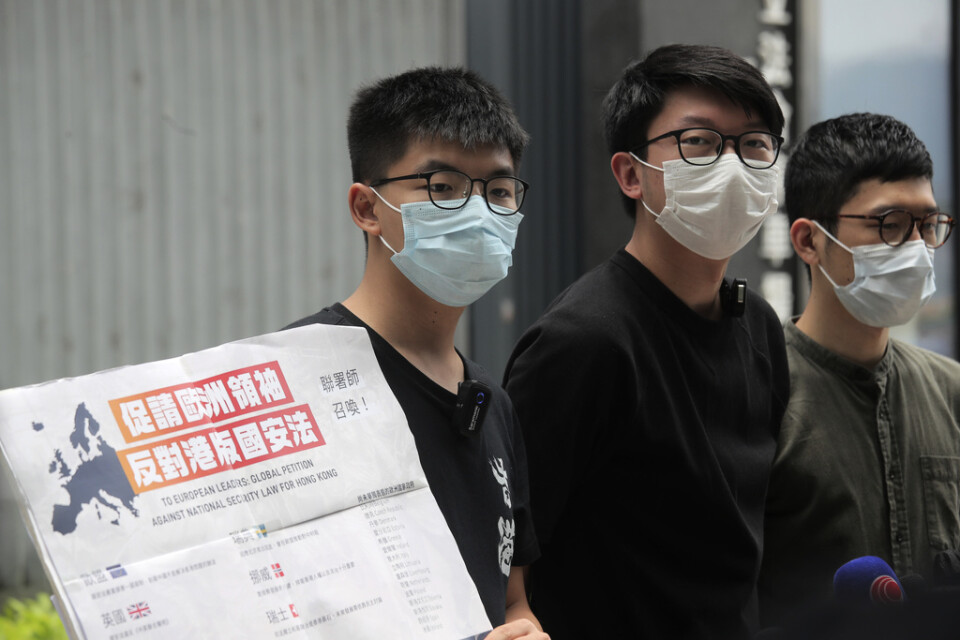 Demokratiaktivisterna Joshua Wong (till vänster), Sunny Cheung (mitten) och Nathan Law med ett plakat som uppmanar europeiska ledare att ta strid mot Kinas planer på att beskära Hongkongs autonomi genom en ny nationell säkerhetslag.