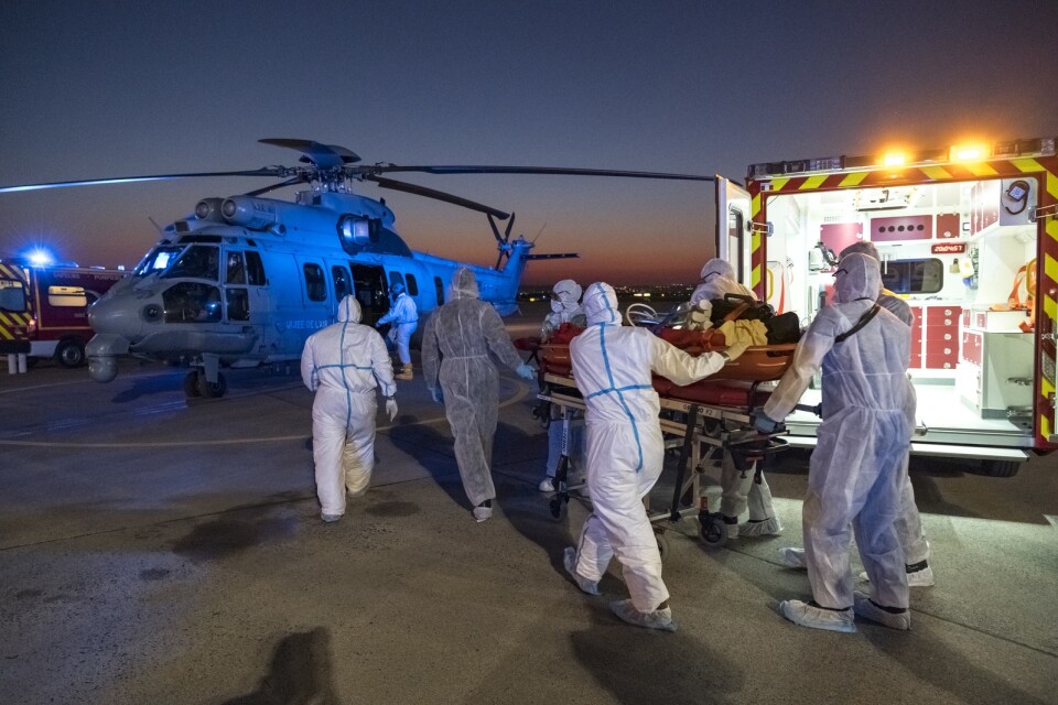 Vårdpersonal transporterar en intensivvårdspatient till en helikopter på Parisflygplatsen Orly, för vård i regioner som är mindre pressade. Bilden har tillhandahållits av den franska militären.