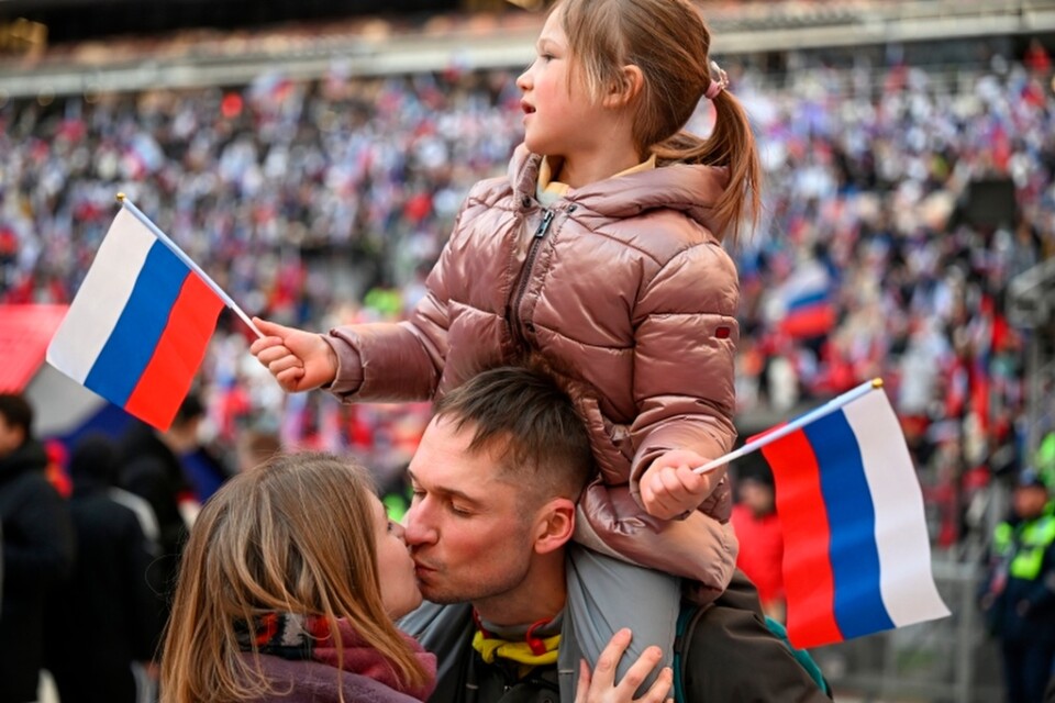 Ett ungt par kyssar varandra under en patriotisk konsert i Moskva i mars 2022.