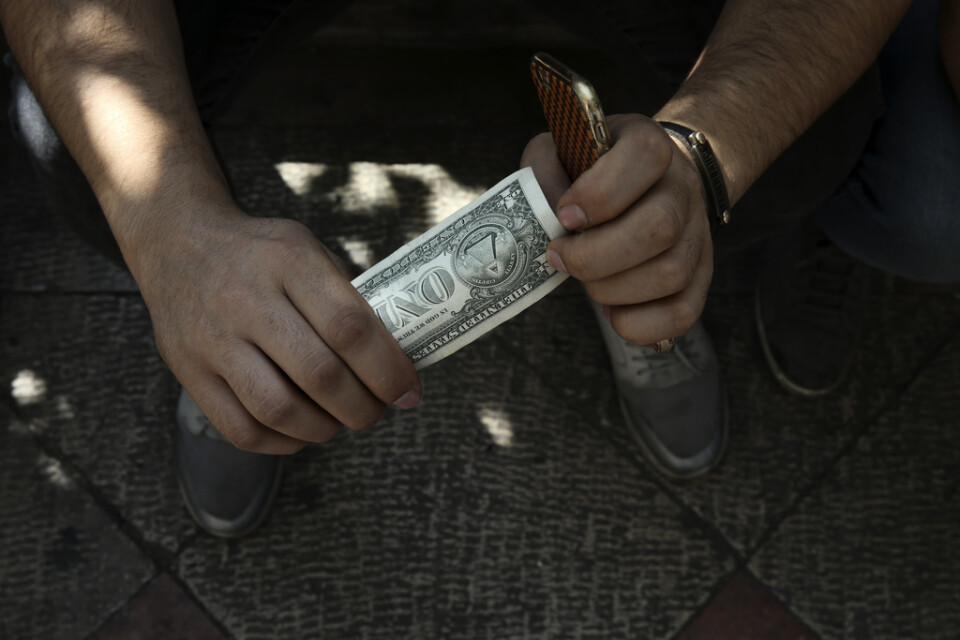 En svartväxlare på en gata i Irans huvudstad Teheran med dollar i handen. Arkivbild.