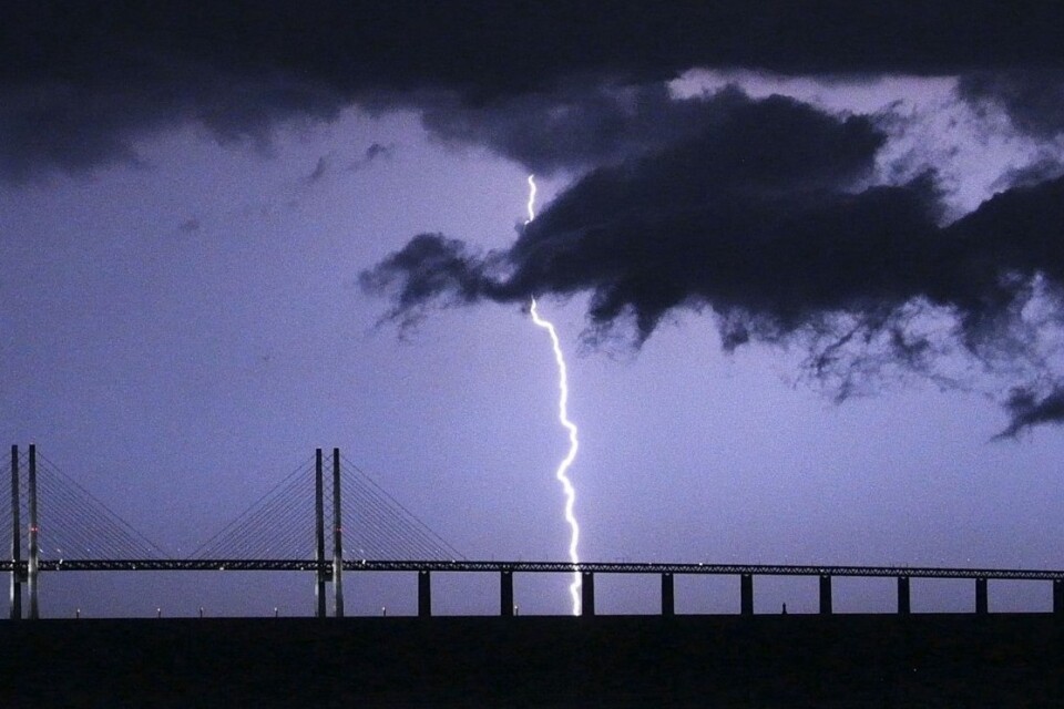 En blixt slår ner bakom Öresundsbron då en åskfront drar in över Öresund. 
Foto: Johan Nilsson/TT