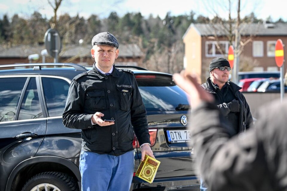Rasmus Paludan (till vänster), partiledare för det danska högerextrema partiet Stram kurs, med en koran i handen, på plats i Rinkeby.