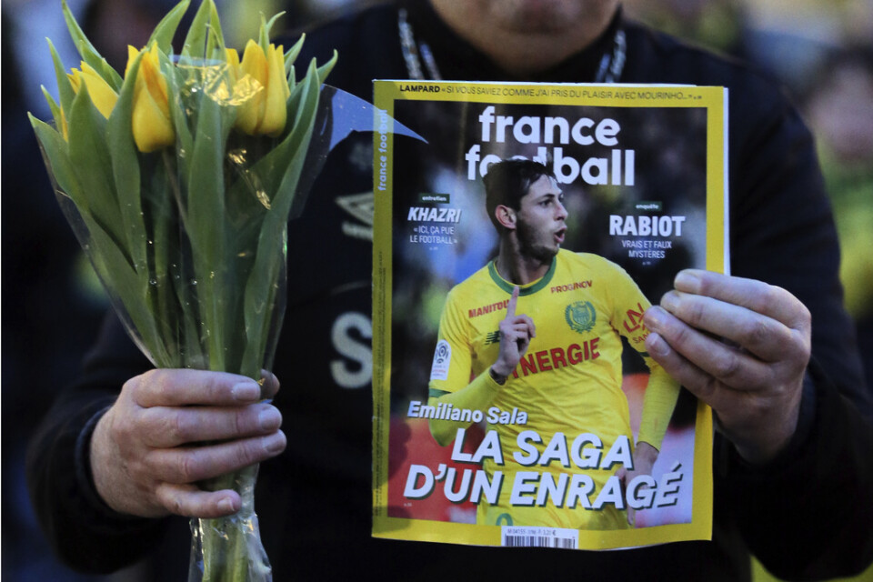 En Nantes-supporter med en fotbollstidning vars omslag pryds av Emilano Sala. Arkivbild.