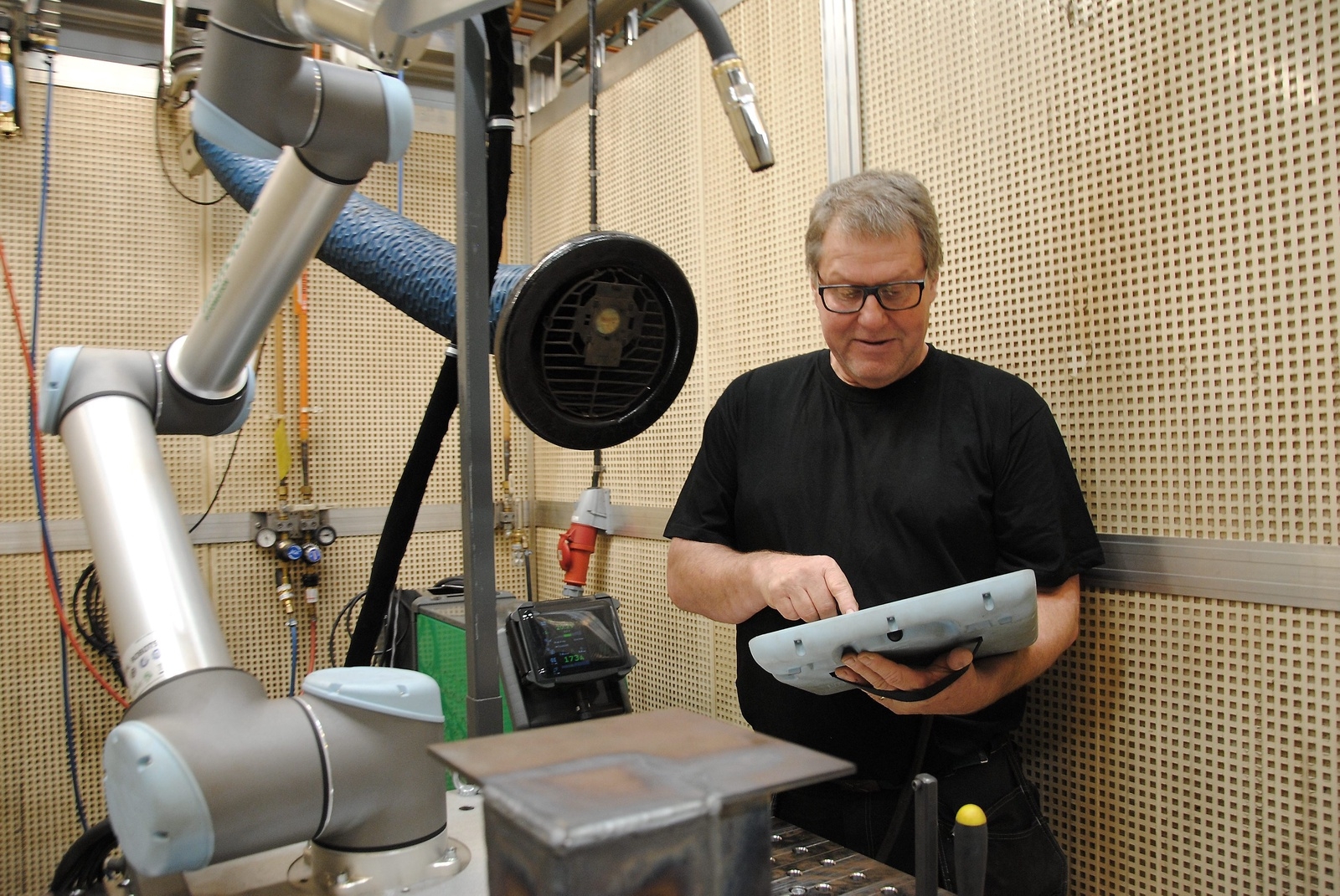 Peter Olofsson, programansvarig på industriprogrammet, testar den nya svetsroboten.