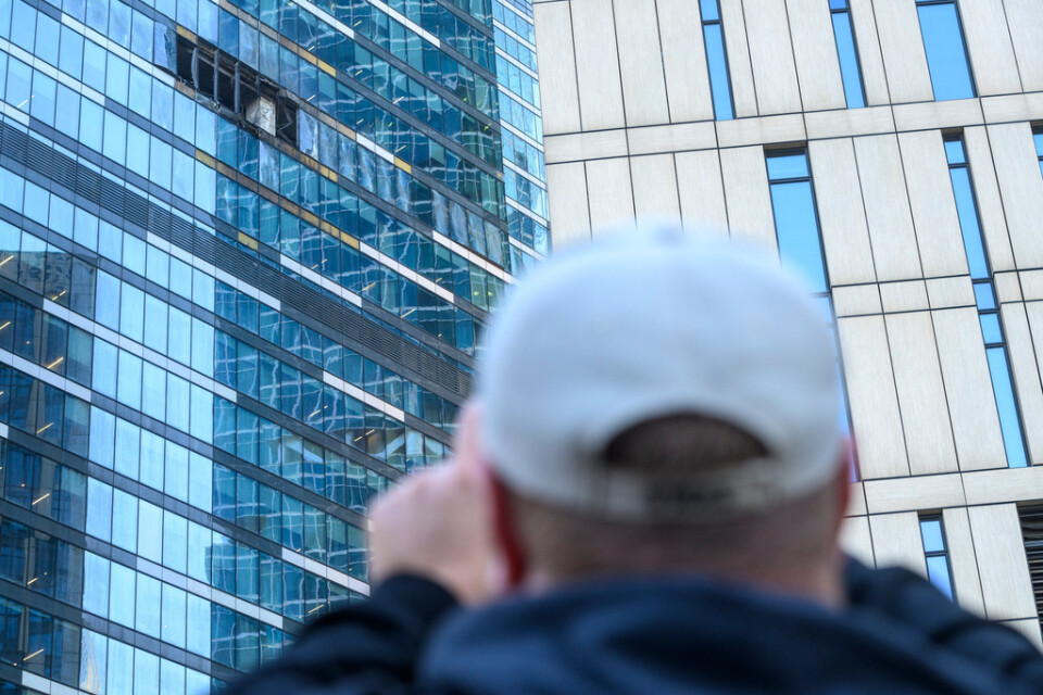 En man fotograferar skadorna efter att en drönarattack träffat en byggnad i Moskvas affärsdistrikt. Arkivbild.