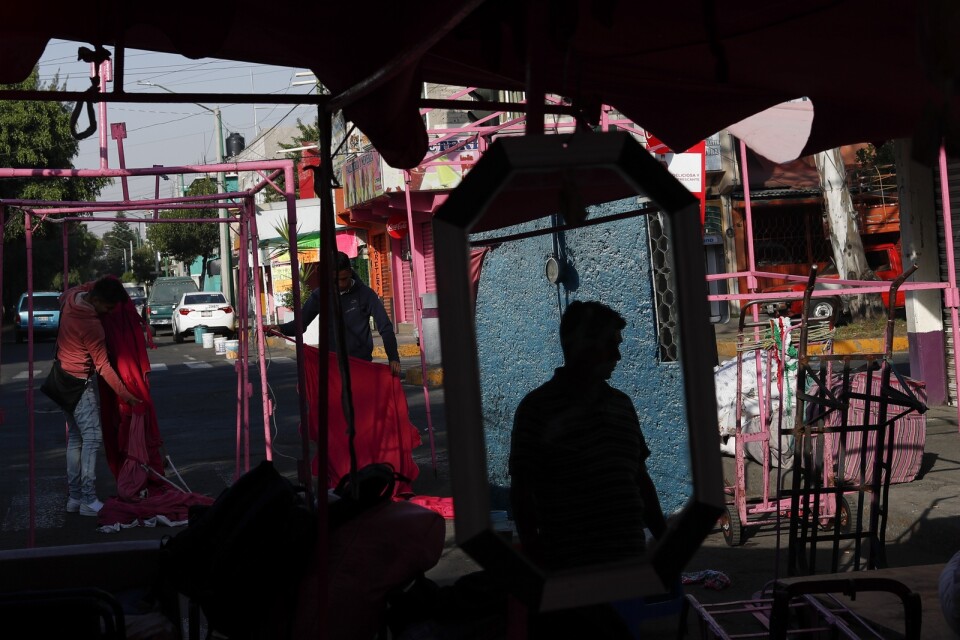 Gatuförsäljare förbereder sig för en arbetsdag på en marknad i Mexico City. Arkivbild från i slutet av mars.