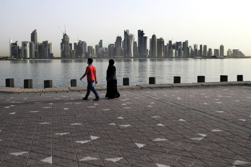 Ett par på promenad vid vattnet framför Dohas skyline, i maj 2018. Arkivbild.