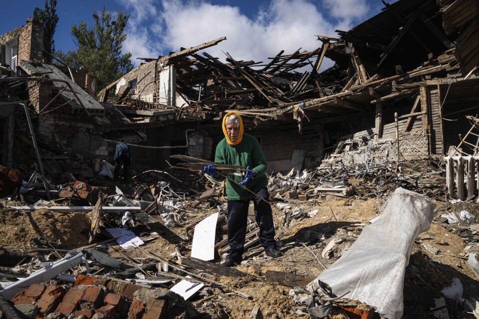 Tetyana samlar ihop lite ved från en förstörd skola i Charkiv. Hennes hemstad är en av många städer som bombats under det ryska kriget, som startade den 24 februari.