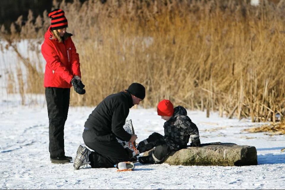 Förberedda för en dag på isen. Anna Mårtensson, maken Patrik Haugland och sonen Albin Haugland har klätt sig varmt och gör sig beredda för säsongens första åkning på naturis.