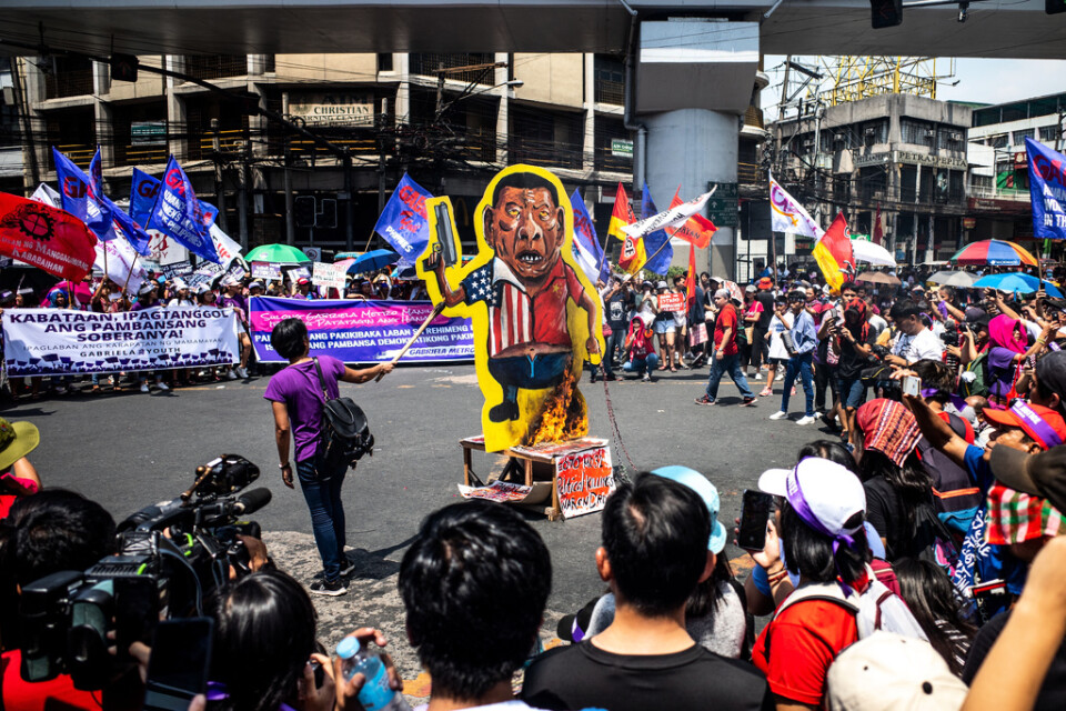En karikatyr av Filippinernas president Rodrigo Duterte brändes vid en demonstration i Manila.